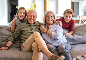A family sitting on the couch. Links to Gifts by Will or Trust